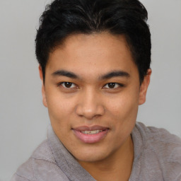 Joyful latino young-adult male with short  brown hair and brown eyes