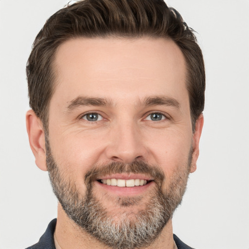 Joyful white adult male with short  brown hair and brown eyes