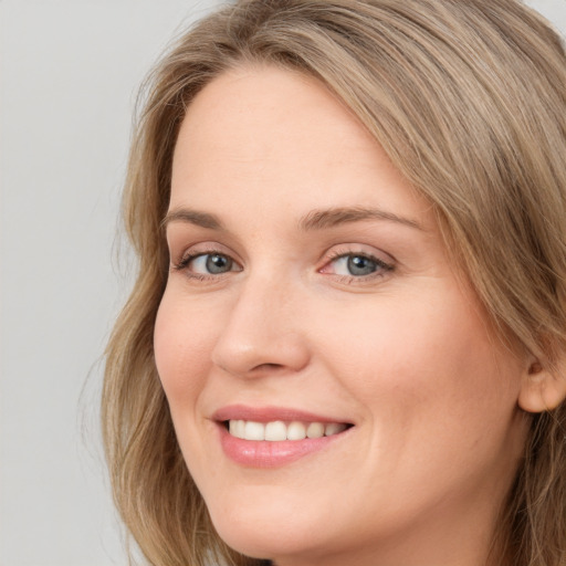 Joyful white young-adult female with long  brown hair and green eyes