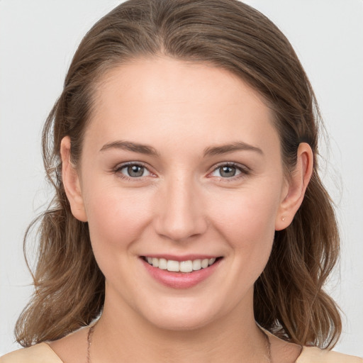 Joyful white young-adult female with medium  brown hair and grey eyes