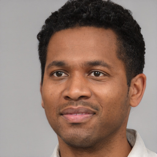 Joyful black young-adult male with short  black hair and brown eyes