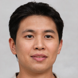 Joyful asian young-adult male with short  brown hair and brown eyes