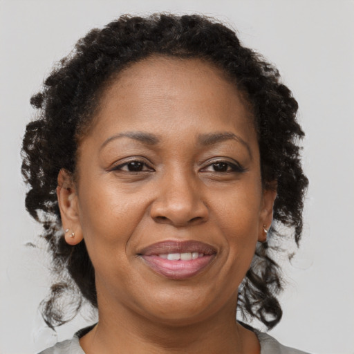 Joyful black adult female with medium  brown hair and brown eyes