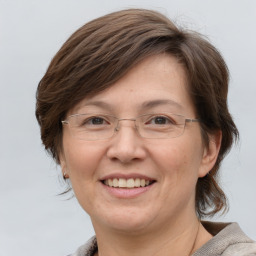 Joyful white adult female with medium  brown hair and grey eyes