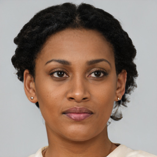 Joyful black young-adult female with short  brown hair and brown eyes
