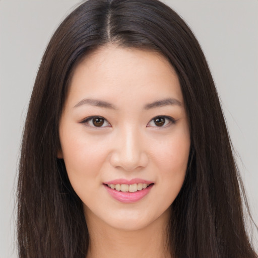 Joyful asian young-adult female with long  brown hair and brown eyes