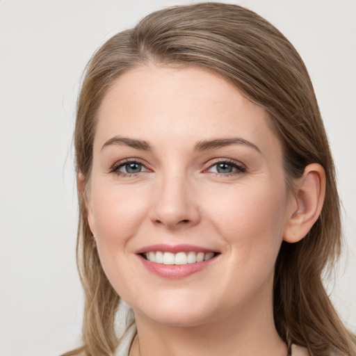 Joyful white young-adult female with long  brown hair and grey eyes