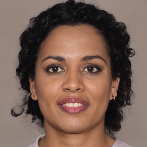 Joyful black young-adult female with medium  black hair and brown eyes
