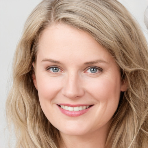 Joyful white young-adult female with long  brown hair and blue eyes