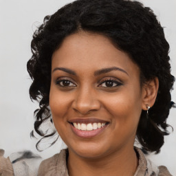 Joyful black young-adult female with long  brown hair and brown eyes