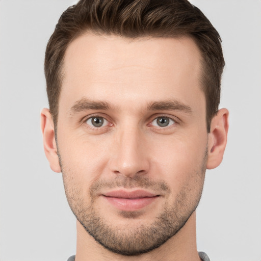 Joyful white young-adult male with short  brown hair and grey eyes