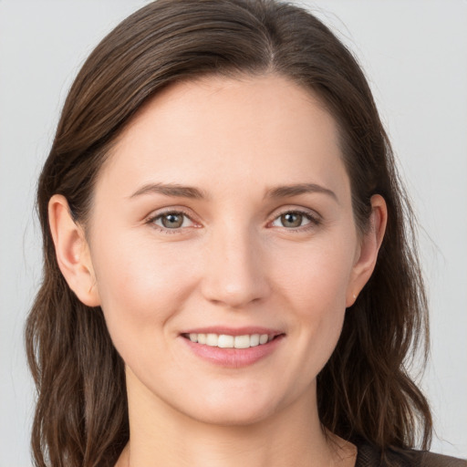 Joyful white young-adult female with long  brown hair and grey eyes