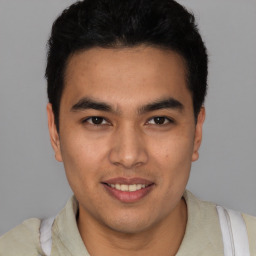 Joyful latino young-adult male with short  brown hair and brown eyes