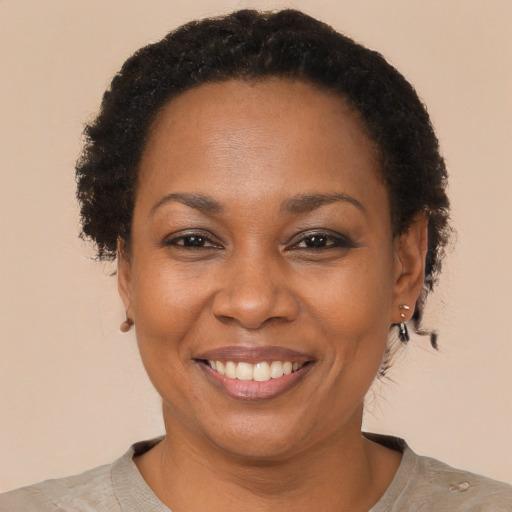 Joyful black adult female with short  brown hair and brown eyes