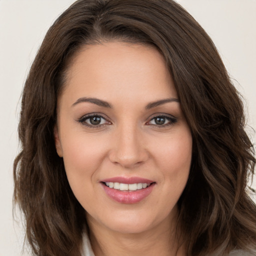 Joyful white young-adult female with long  brown hair and brown eyes