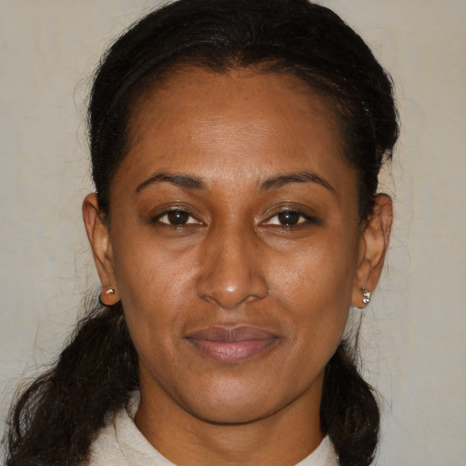 Joyful black adult female with medium  brown hair and brown eyes