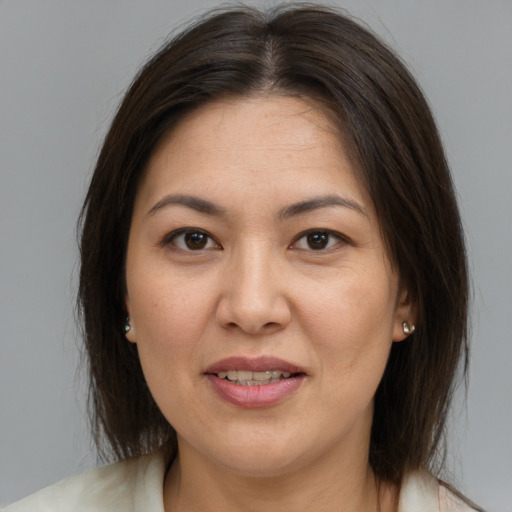 Joyful asian adult female with medium  brown hair and brown eyes
