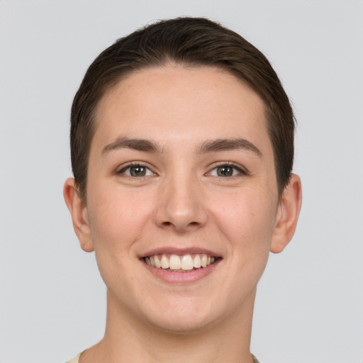 Joyful white young-adult female with short  brown hair and grey eyes