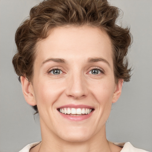 Joyful white young-adult female with short  brown hair and green eyes