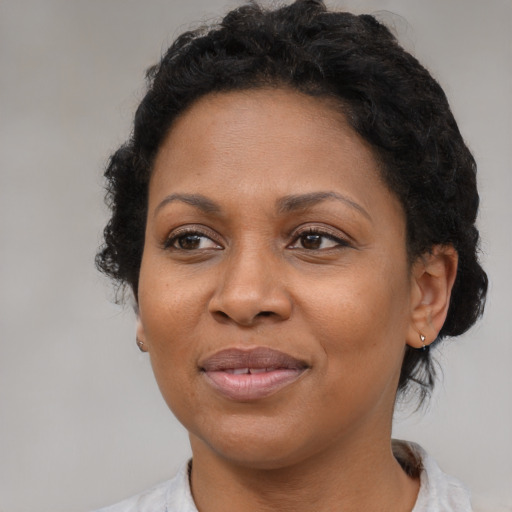 Joyful black adult female with medium  brown hair and brown eyes