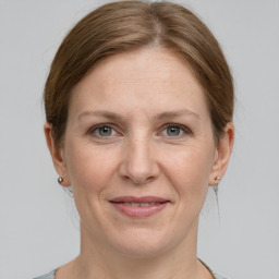 Joyful white adult female with medium  brown hair and grey eyes