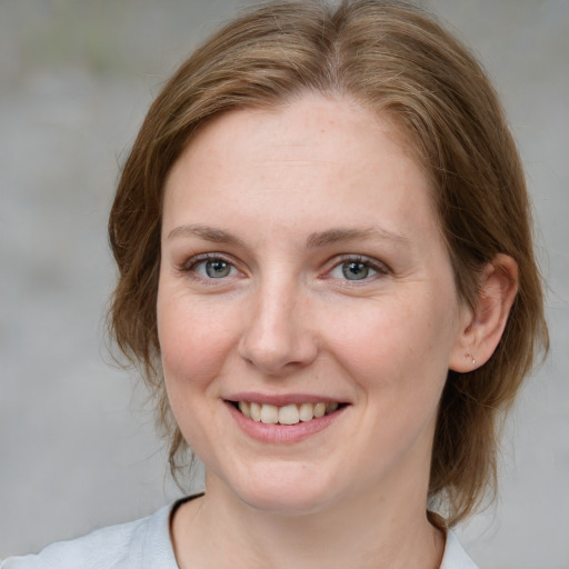 Joyful white young-adult female with medium  brown hair and blue eyes