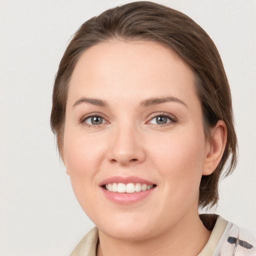 Joyful white young-adult female with medium  brown hair and green eyes