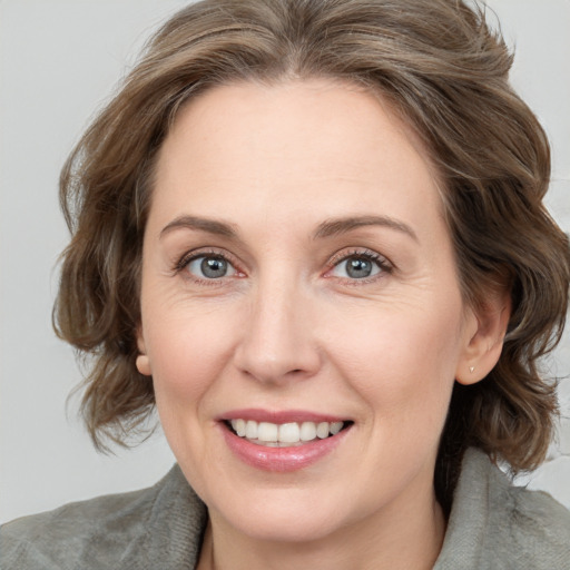 Joyful white adult female with medium  brown hair and grey eyes