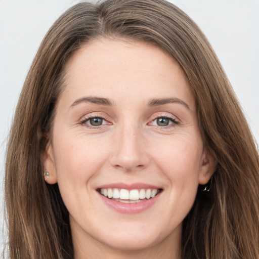 Joyful white young-adult female with long  brown hair and green eyes