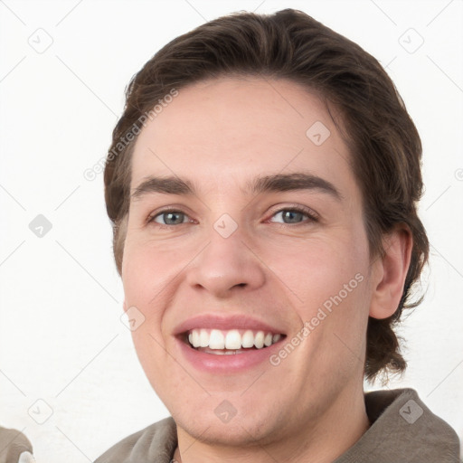 Joyful white young-adult male with short  brown hair and grey eyes