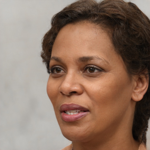 Joyful black adult female with short  brown hair and brown eyes