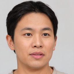 Joyful asian young-adult male with short  brown hair and brown eyes