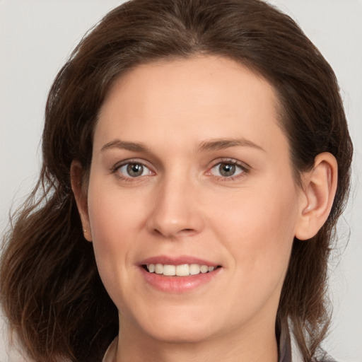 Joyful white young-adult female with medium  brown hair and grey eyes