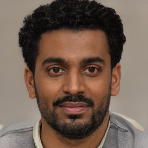 Joyful black young-adult male with short  black hair and brown eyes