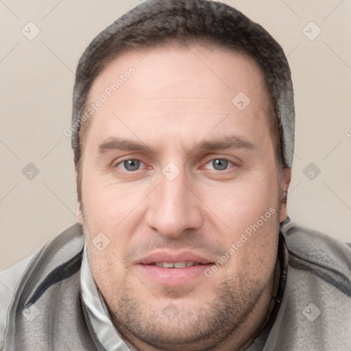 Joyful white young-adult male with short  brown hair and grey eyes