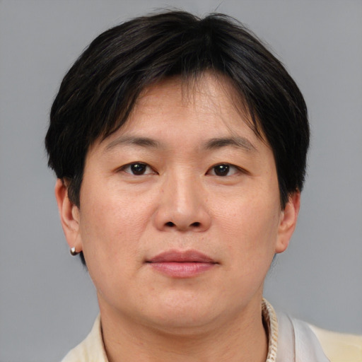 Joyful asian adult male with short  brown hair and brown eyes
