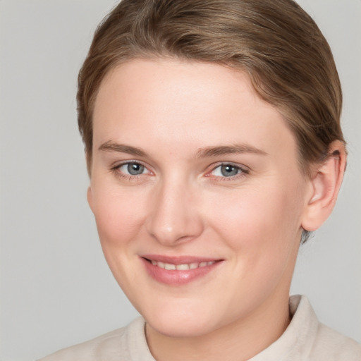 Joyful white young-adult female with short  brown hair and grey eyes