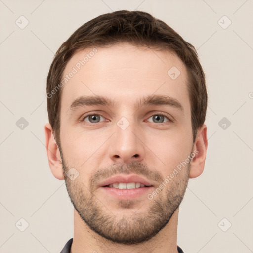 Joyful white young-adult male with short  brown hair and grey eyes