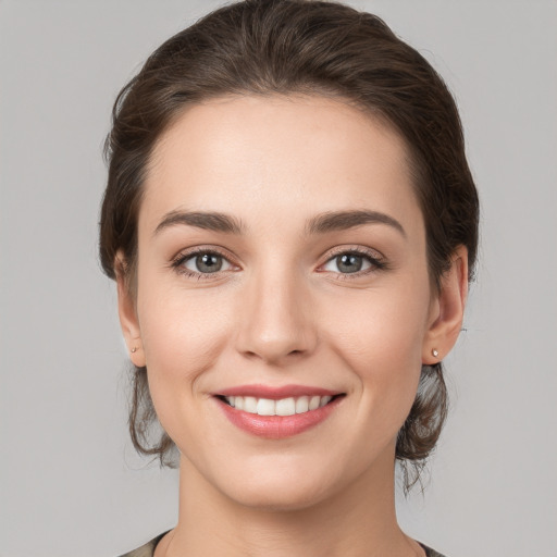 Joyful white young-adult female with medium  brown hair and grey eyes