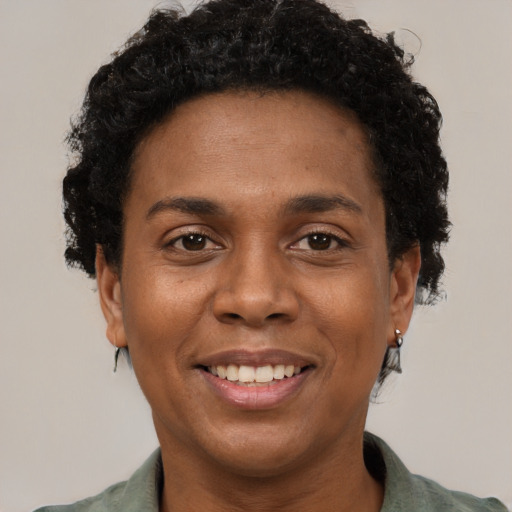 Joyful black adult female with short  brown hair and brown eyes