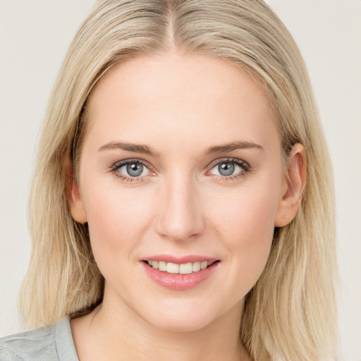 Joyful white young-adult female with long  brown hair and blue eyes