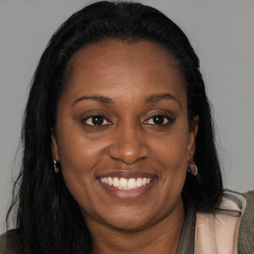 Joyful black adult female with long  brown hair and brown eyes