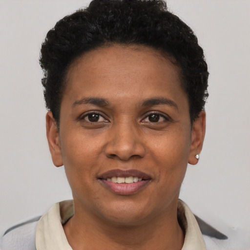 Joyful black young-adult female with short  black hair and brown eyes