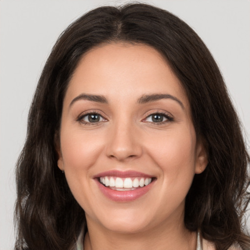 Joyful white young-adult female with long  brown hair and brown eyes