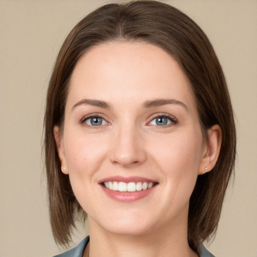 Joyful white young-adult female with medium  brown hair and grey eyes