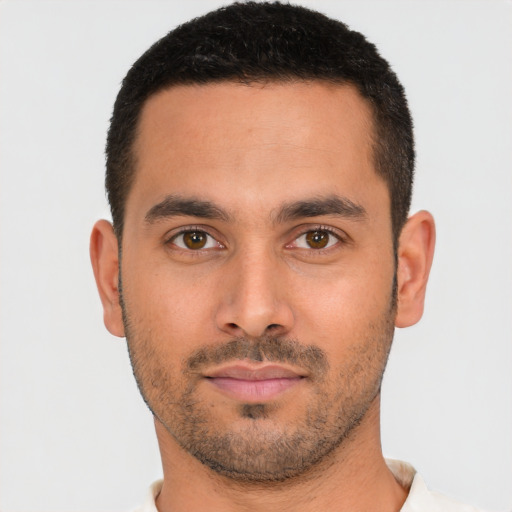 Joyful latino young-adult male with short  brown hair and brown eyes