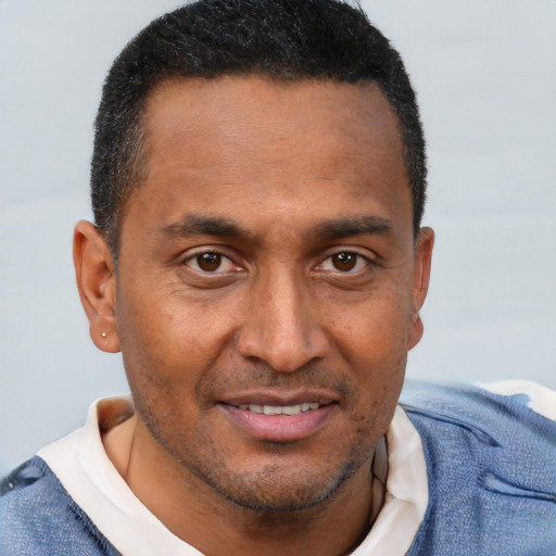 Joyful black adult male with short  brown hair and brown eyes