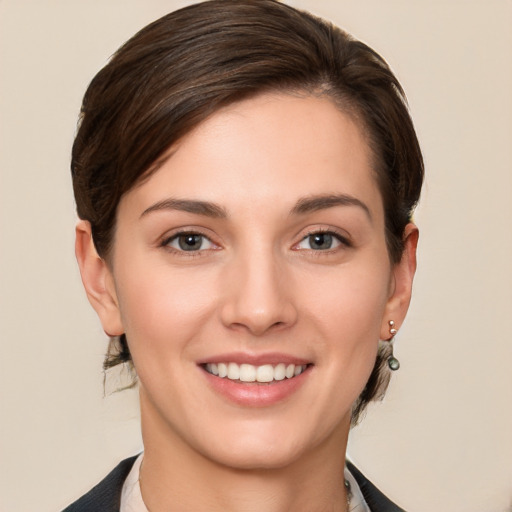 Joyful white young-adult female with short  brown hair and grey eyes