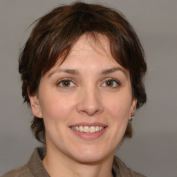 Joyful white adult female with medium  brown hair and grey eyes