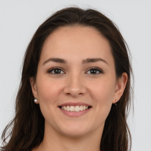 Joyful white young-adult female with long  brown hair and brown eyes